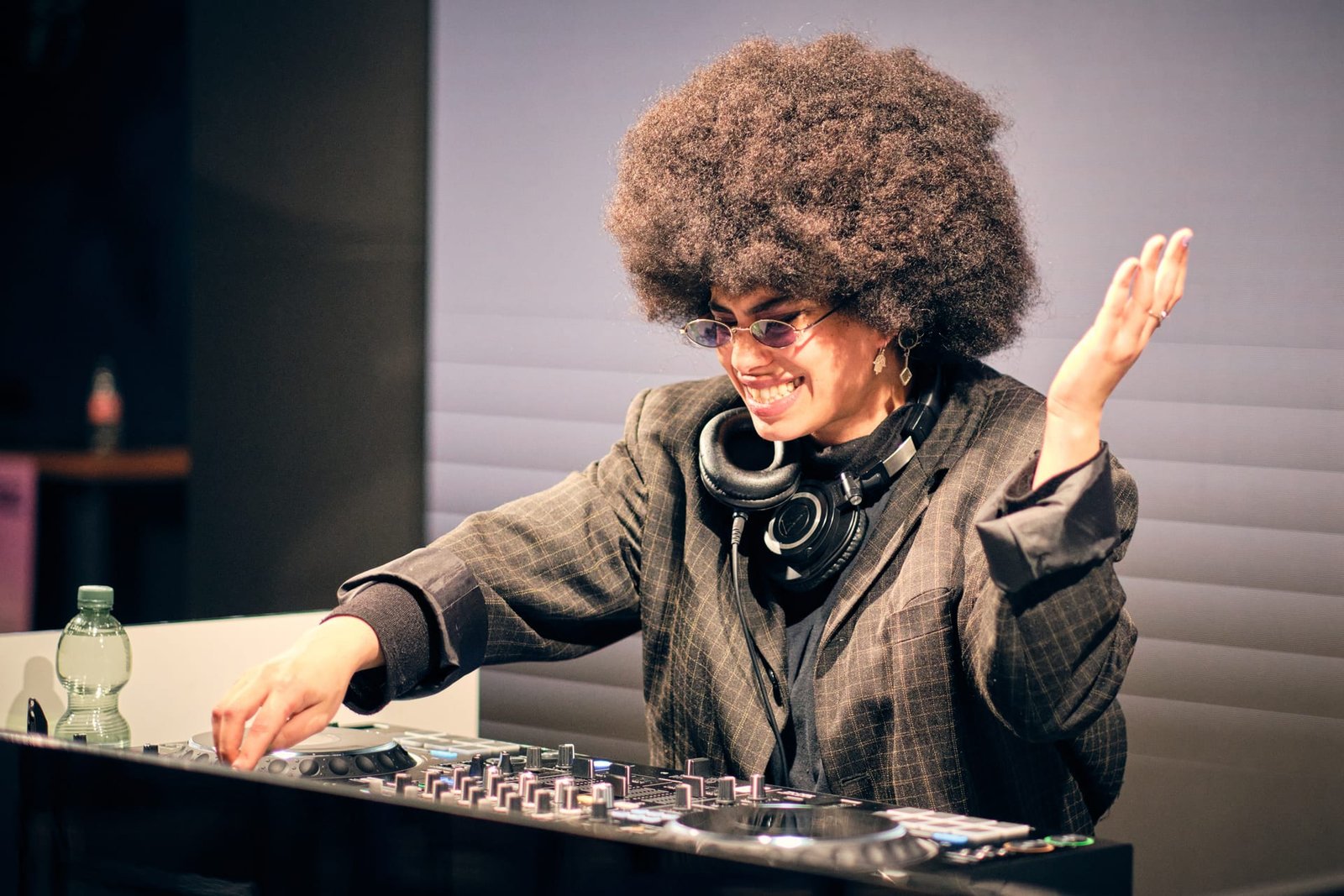 Allynx at the decks, hand raised, warm stage light